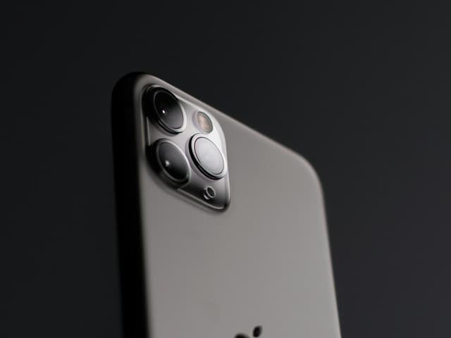 The rear camera array of a modern smartphone, lit against a dark background.